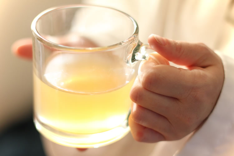 A woman holding a mug of detox tea