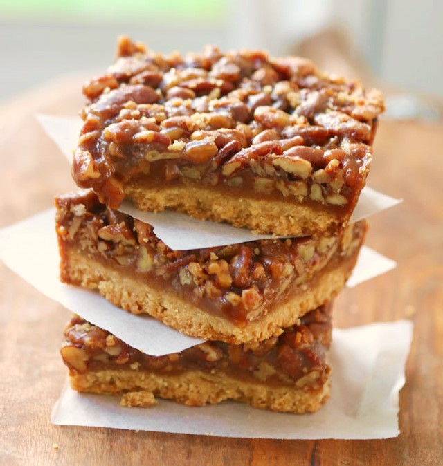 Maple Pecan Pie Bars Recipe with No Corn Syrup stacked in three's on a table with wax paper